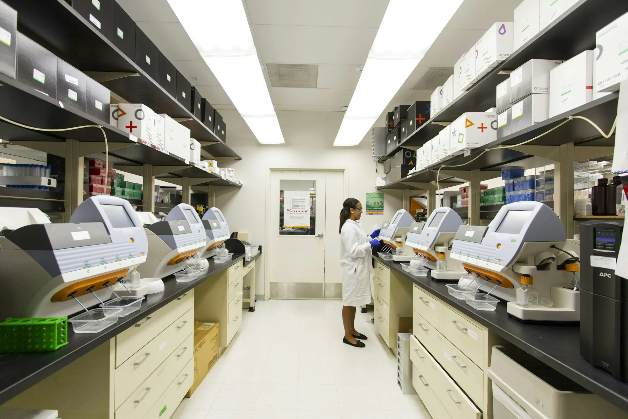 Técnica especializada realizando manutenção em equipamento laboratorial